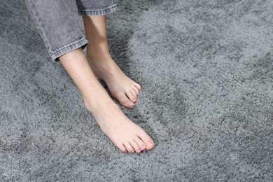 Photo of Girl on soft grey carpet indoors, closeup. Space for text