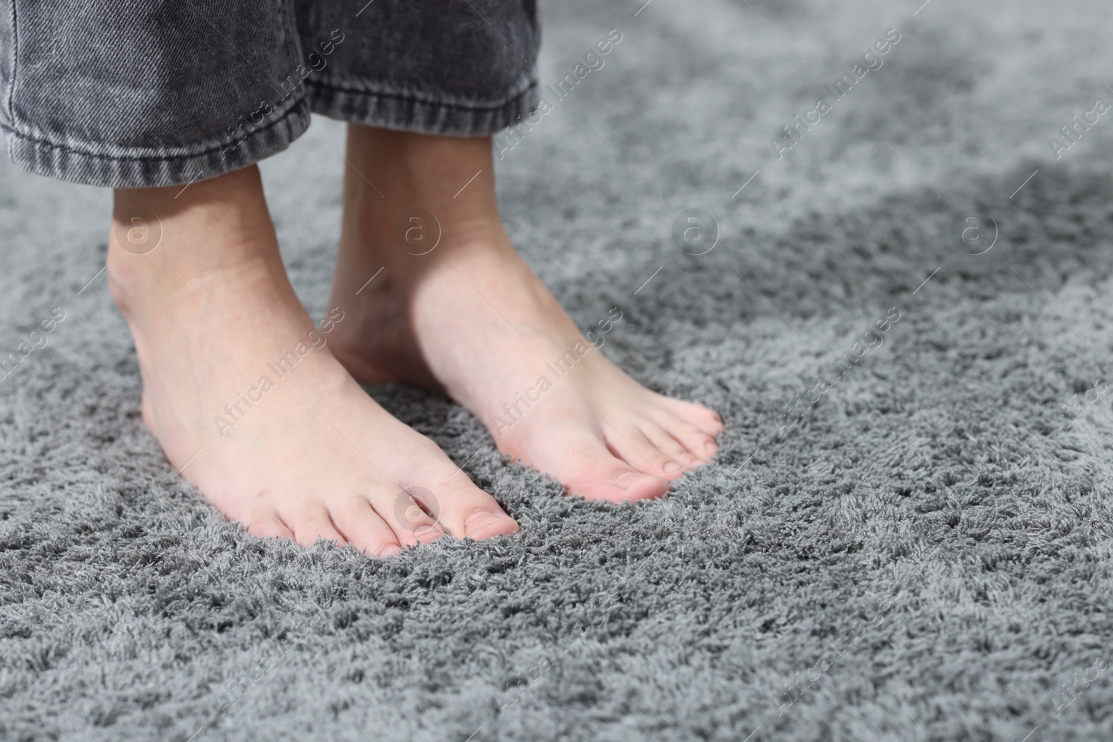 Girl on soft grey carpet indoors, closeup. Space for text Photo of Girl on soft grey carpet indoors, closeup. Space for text
