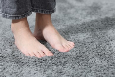 Photo of Girl on soft grey carpet indoors, closeup. Space for text