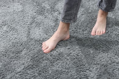 Photo of Girl on soft grey carpet indoors, closeup. Space for text