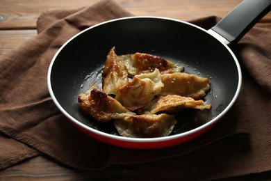 Photo of Tasty fried gyoza (dumplings) on wooden table, closeup