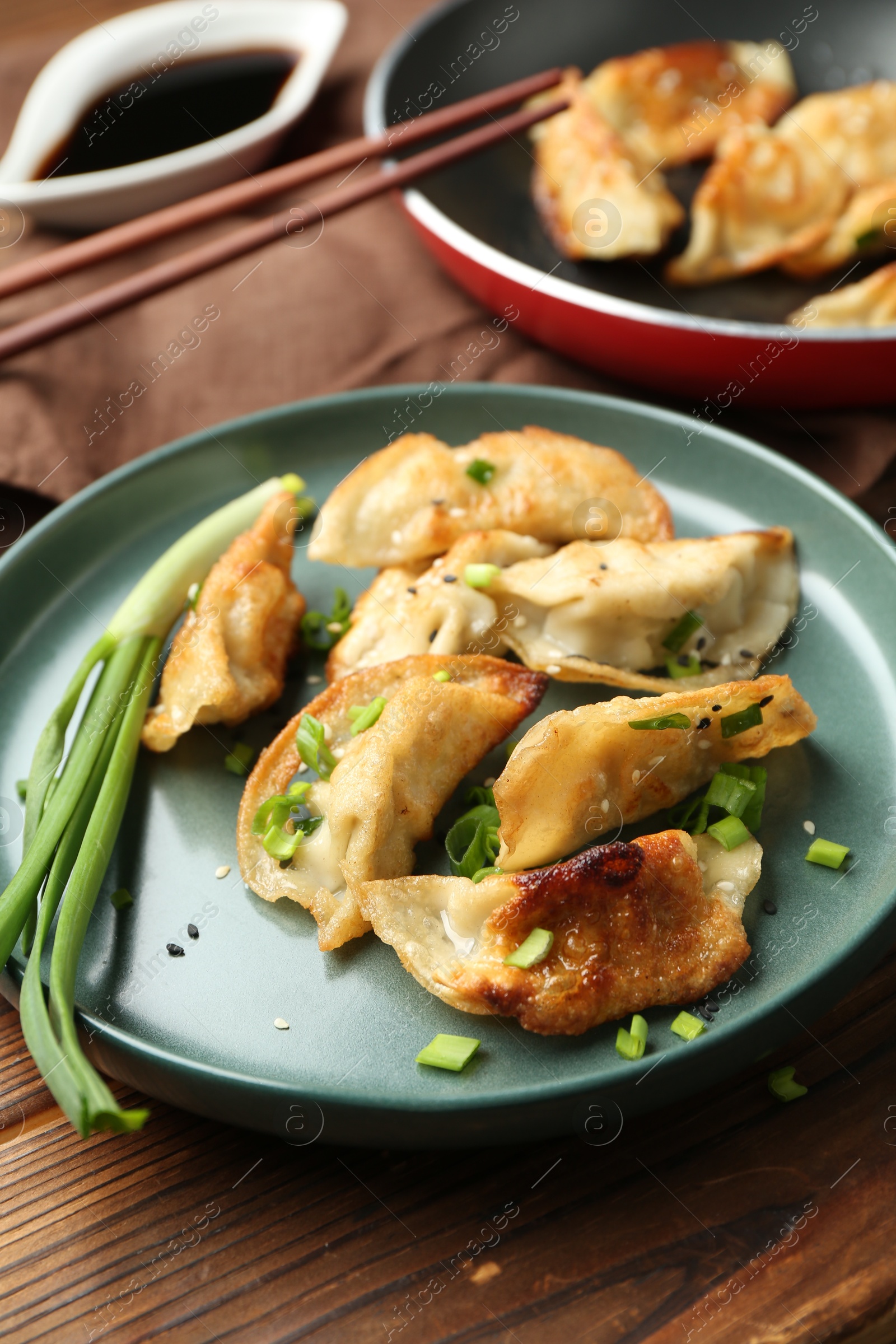 Photo of Tasty fried gyoza (dumplings) on wooden table, closeup