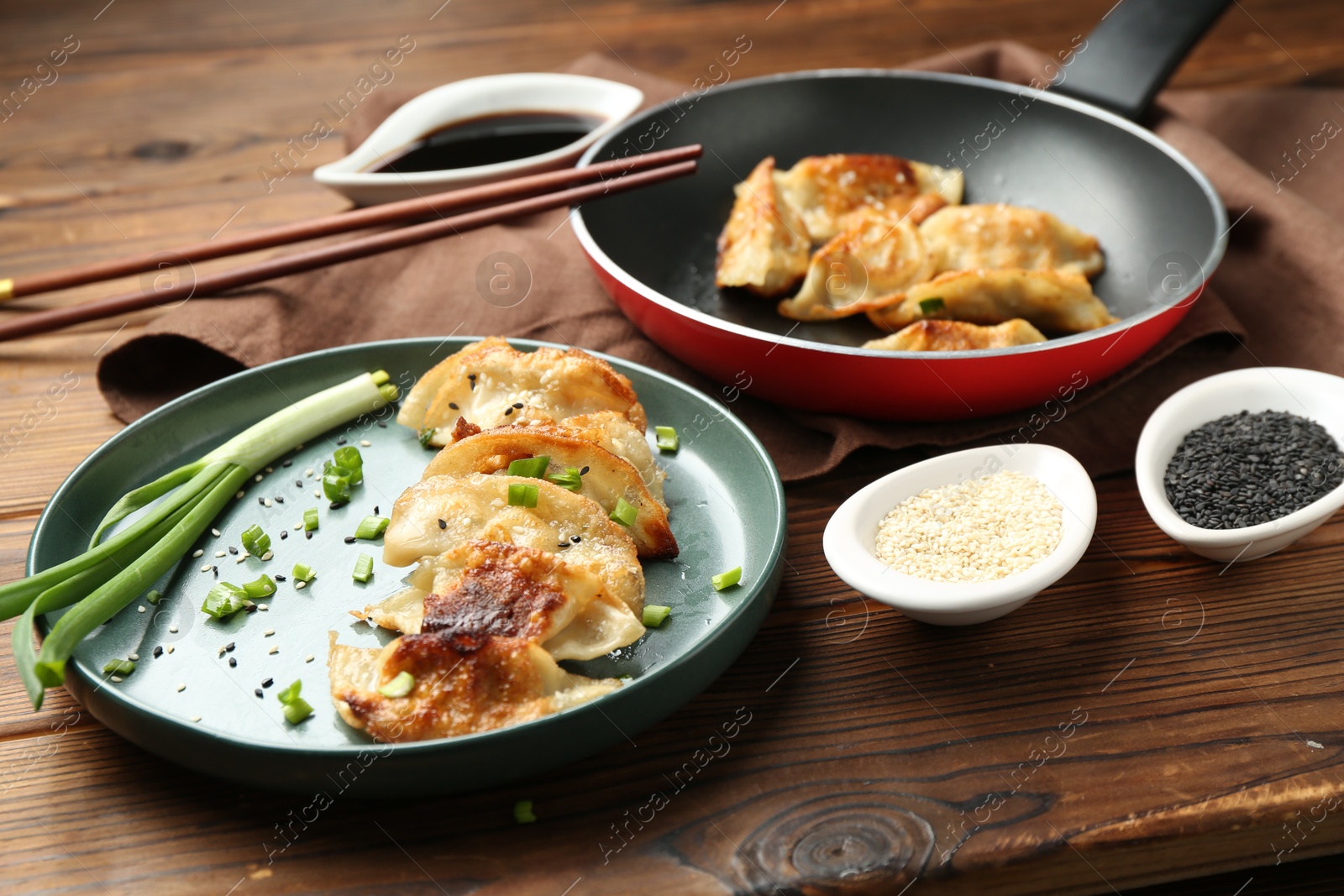 Photo of Tasty fried gyoza (dumplings) on wooden table, closeup