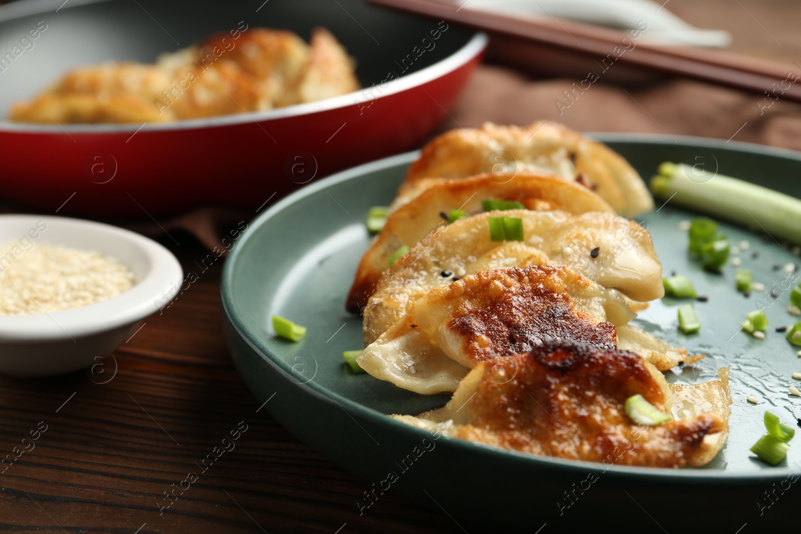 Photo of Tasty fried gyoza (dumplings) on wooden table, closeup