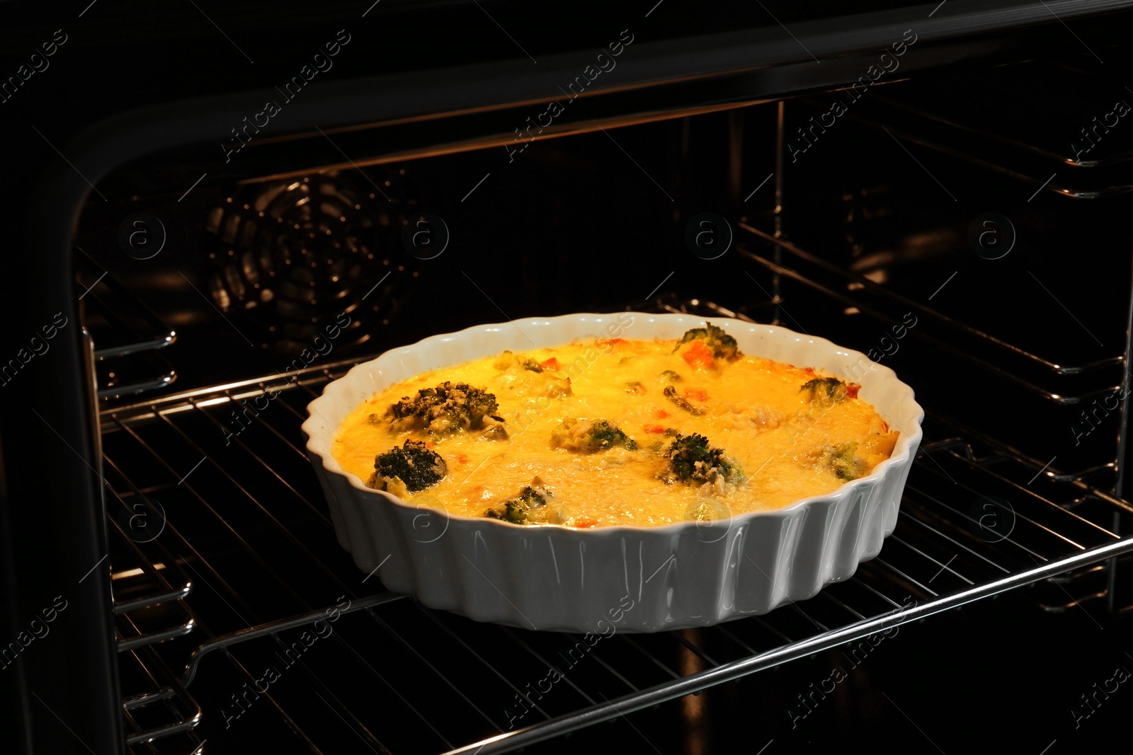 Photo of Baking dish with delicious vegetable casserole in oven