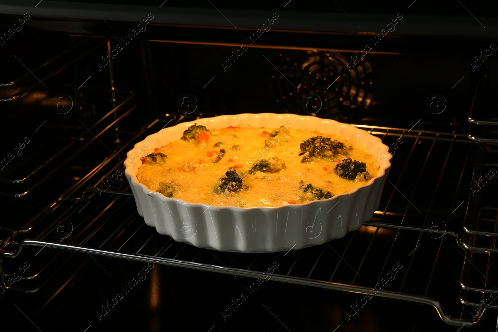 Photo of Baking dish with delicious vegetable casserole in oven