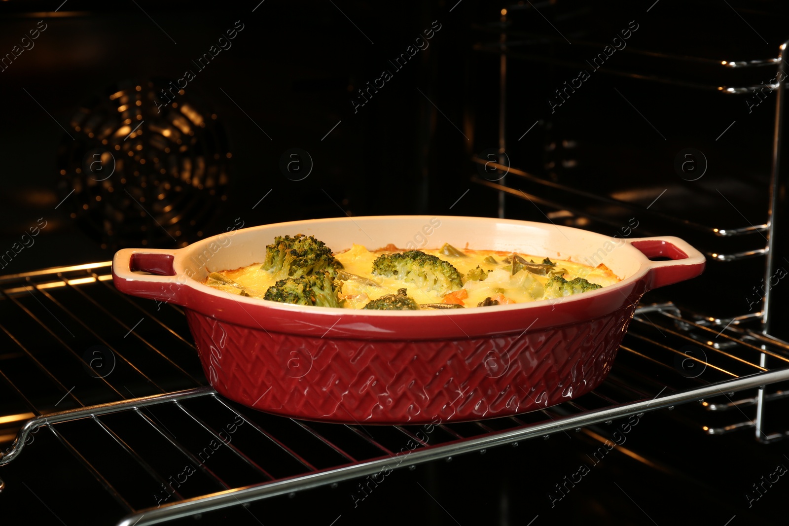 Photo of Baking dish with delicious vegetable casserole in oven