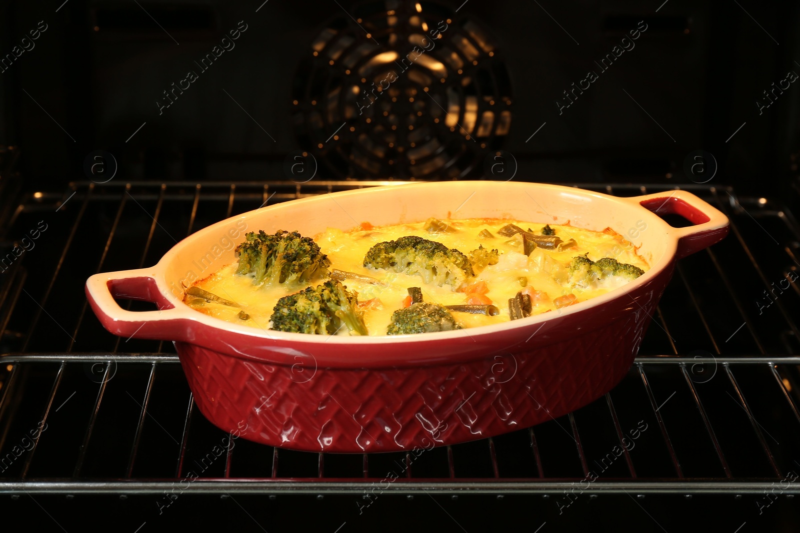 Photo of Delicious vegetable casserole in oven, closeup view