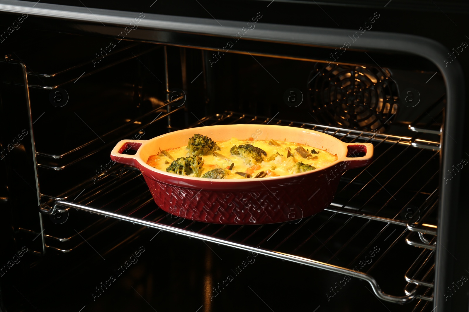 Photo of Baking dish with delicious vegetable casserole in oven