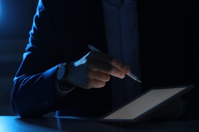 Photo of Electronic signature. Man with stylus and tablet at table in dark office, closeup