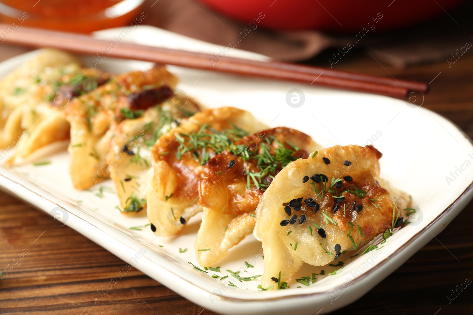 Photo of Tasty fried gyoza (dumpling) on wooden table, closeup