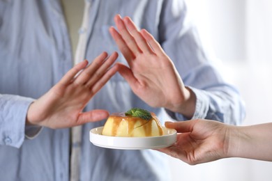 Photo of Woman refusing pudding indoors, selective focus. Food allergy concept