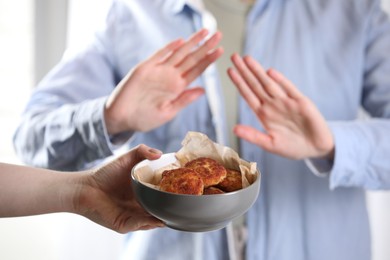 Photo of Woman refusing patties indoors, selective focus. Food allergy concept