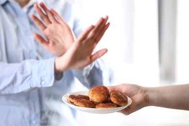 Photo of Woman refusing patties indoors, selective focus. Food allergy concept