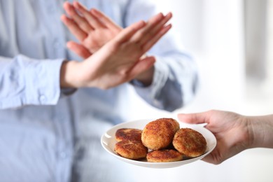 Photo of Woman refusing patties indoors, selective focus. Food allergy concept