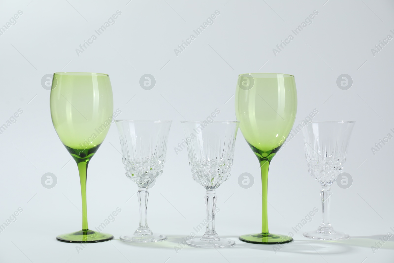 Photo of Many empty clean glasses on light background