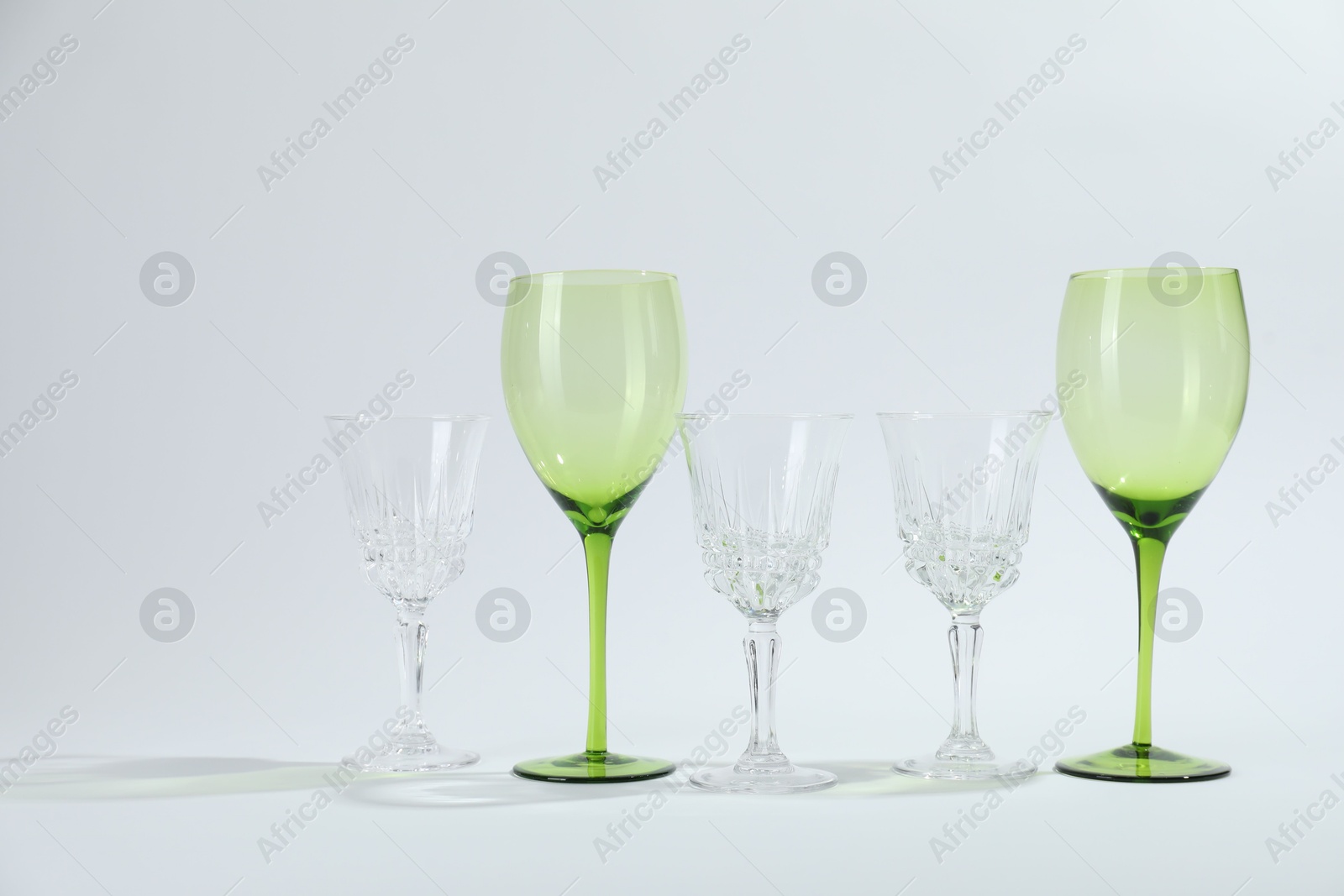 Photo of Many empty clean glasses on light background