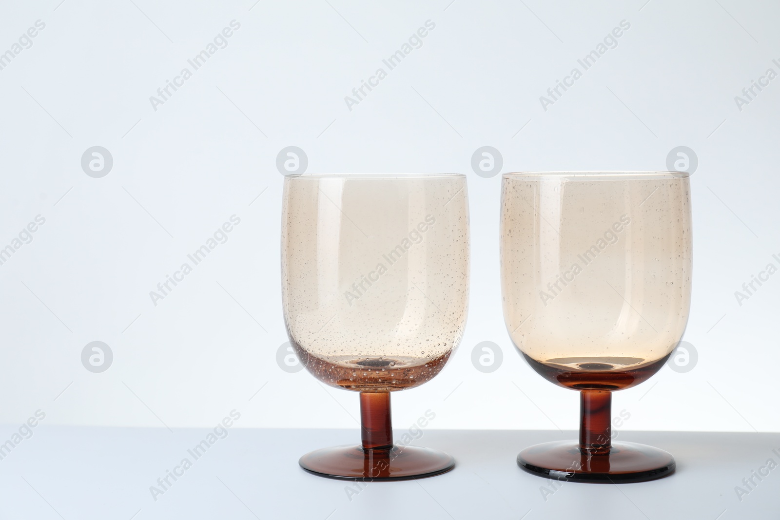 Photo of Two empty clean glasses on light background