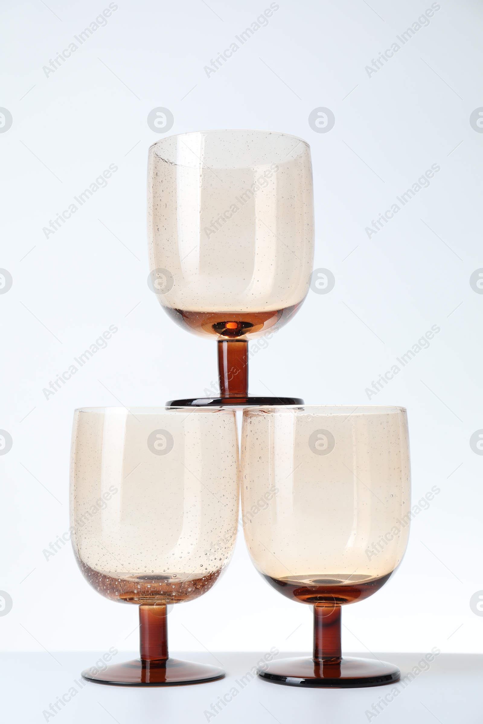 Photo of Three empty clean glasses on light background