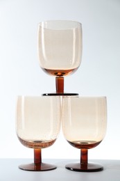 Photo of Three empty clean glasses on light background