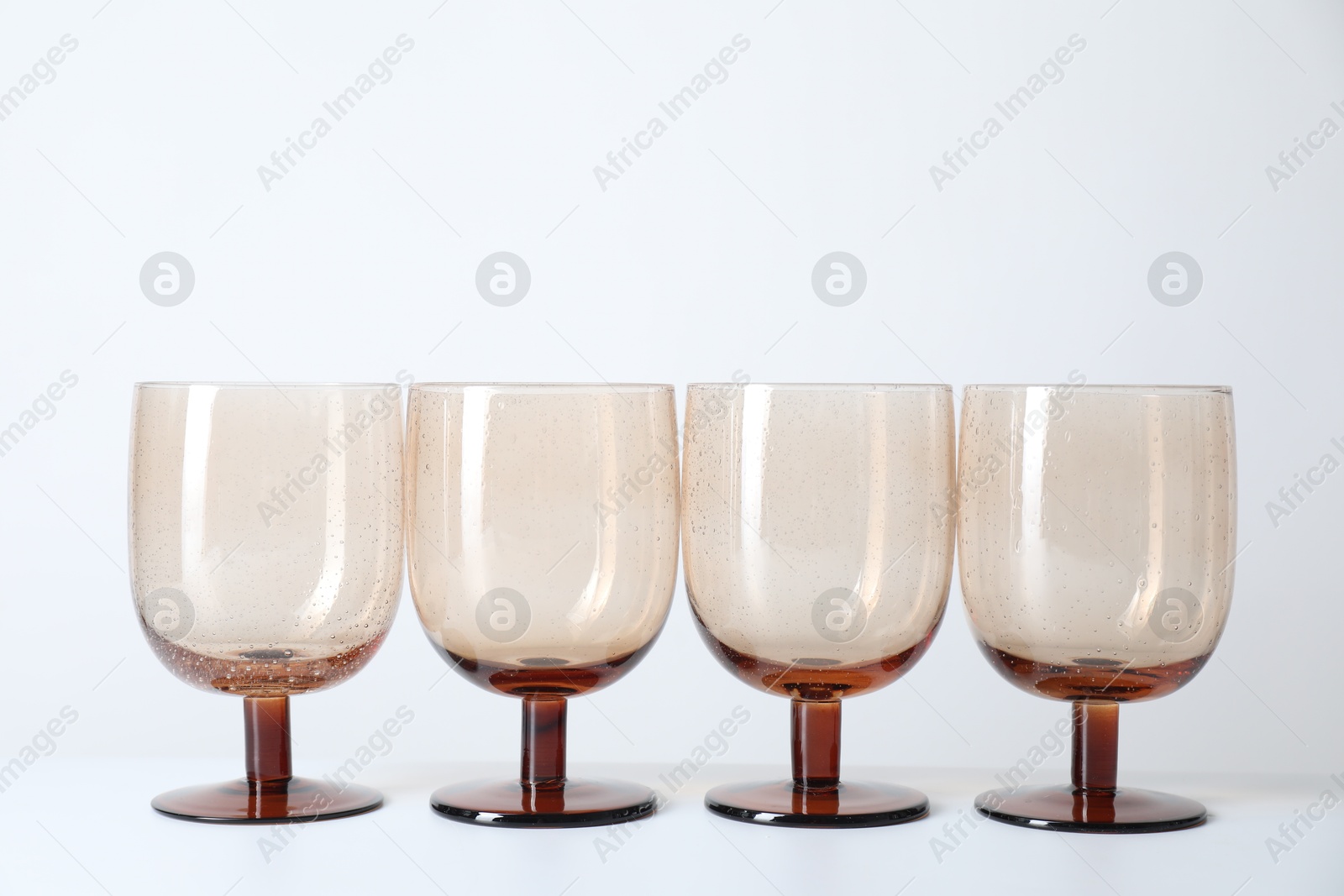 Photo of Many empty clean glasses on light background