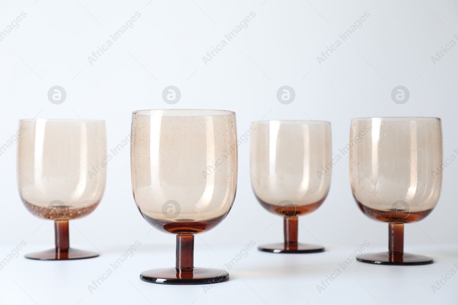 Photo of Many empty clean glasses on light background