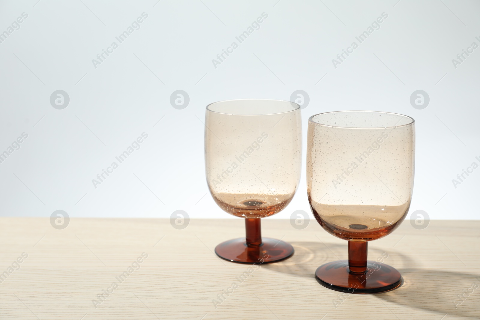 Photo of Two empty clean glasses on wooden table. Space for text