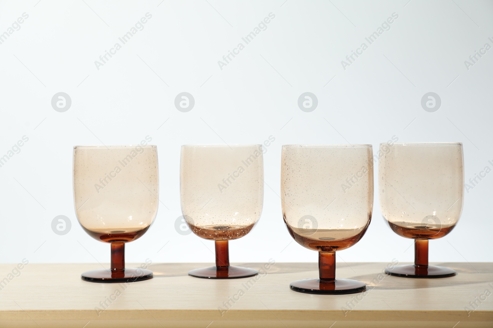 Photo of Many empty clean glasses on wooden table