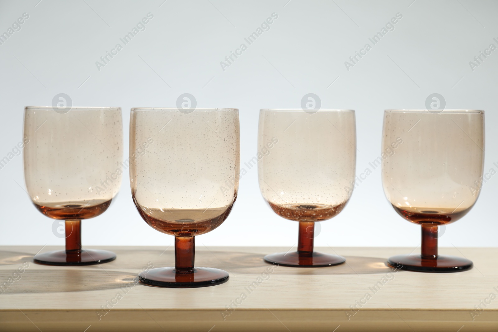 Photo of Many empty clean glasses on wooden table