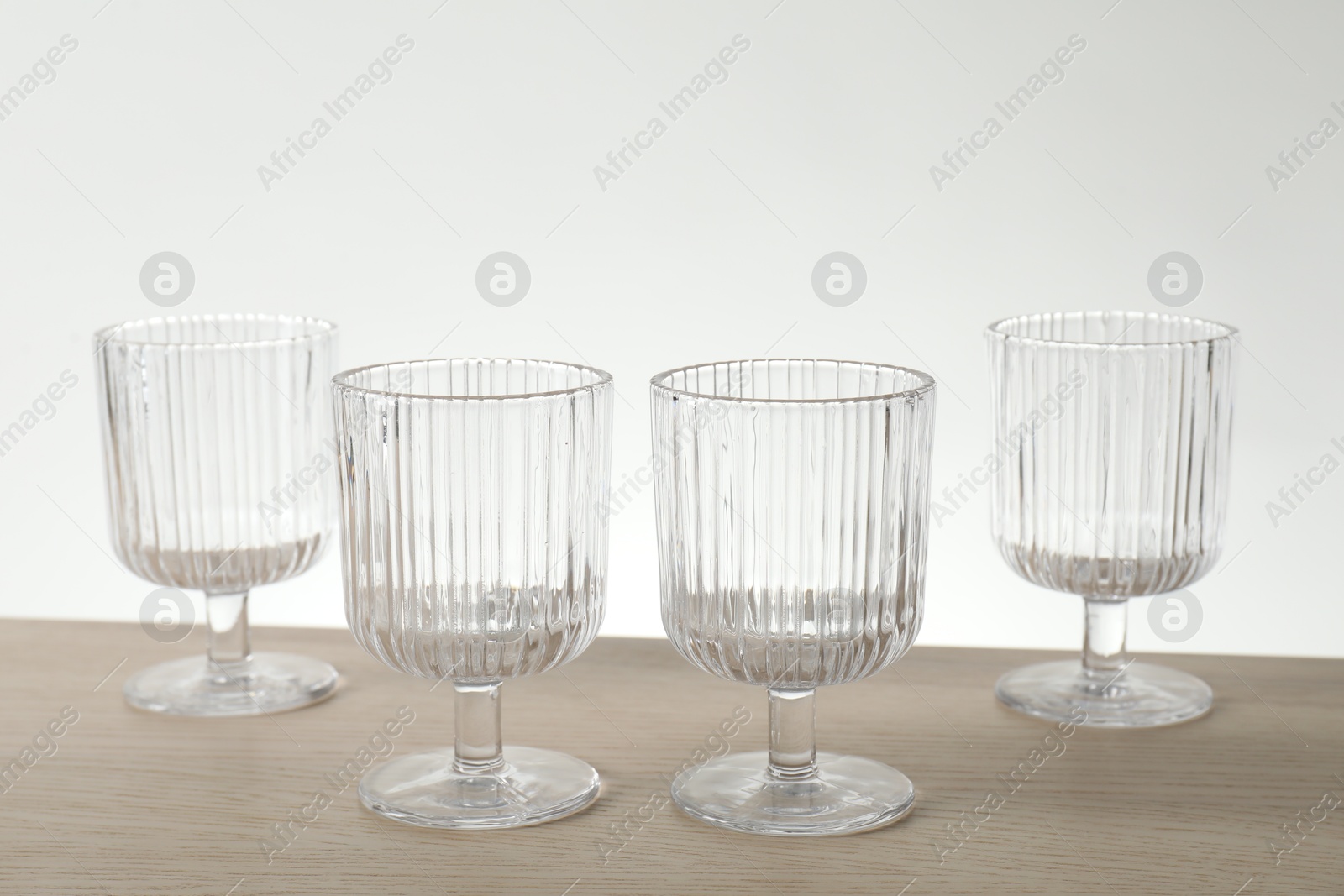 Photo of Many empty clean glasses on wooden table