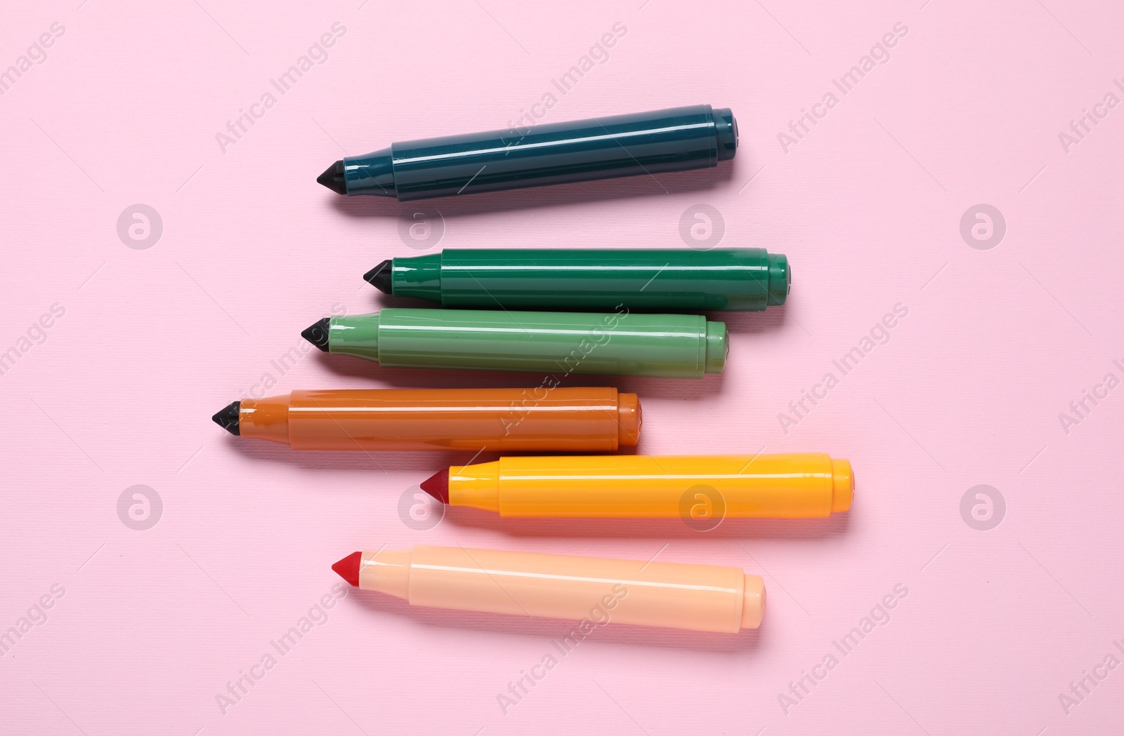 Photo of Many colorful markers on pink background, flat lay
