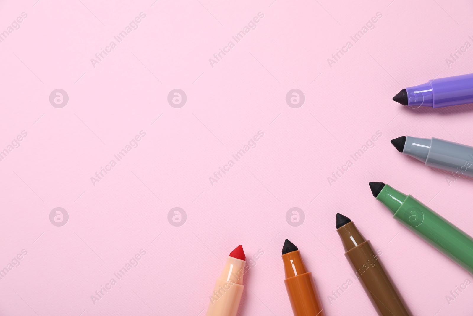 Photo of Many colorful markers on pink background, flat lay. Space for text