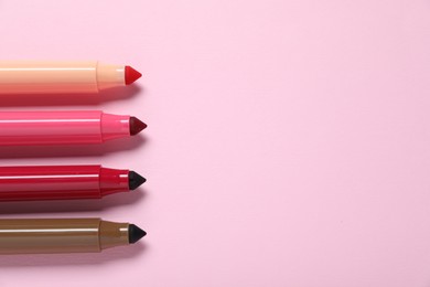 Photo of Many colorful markers on pink background, flat lay. Space for text