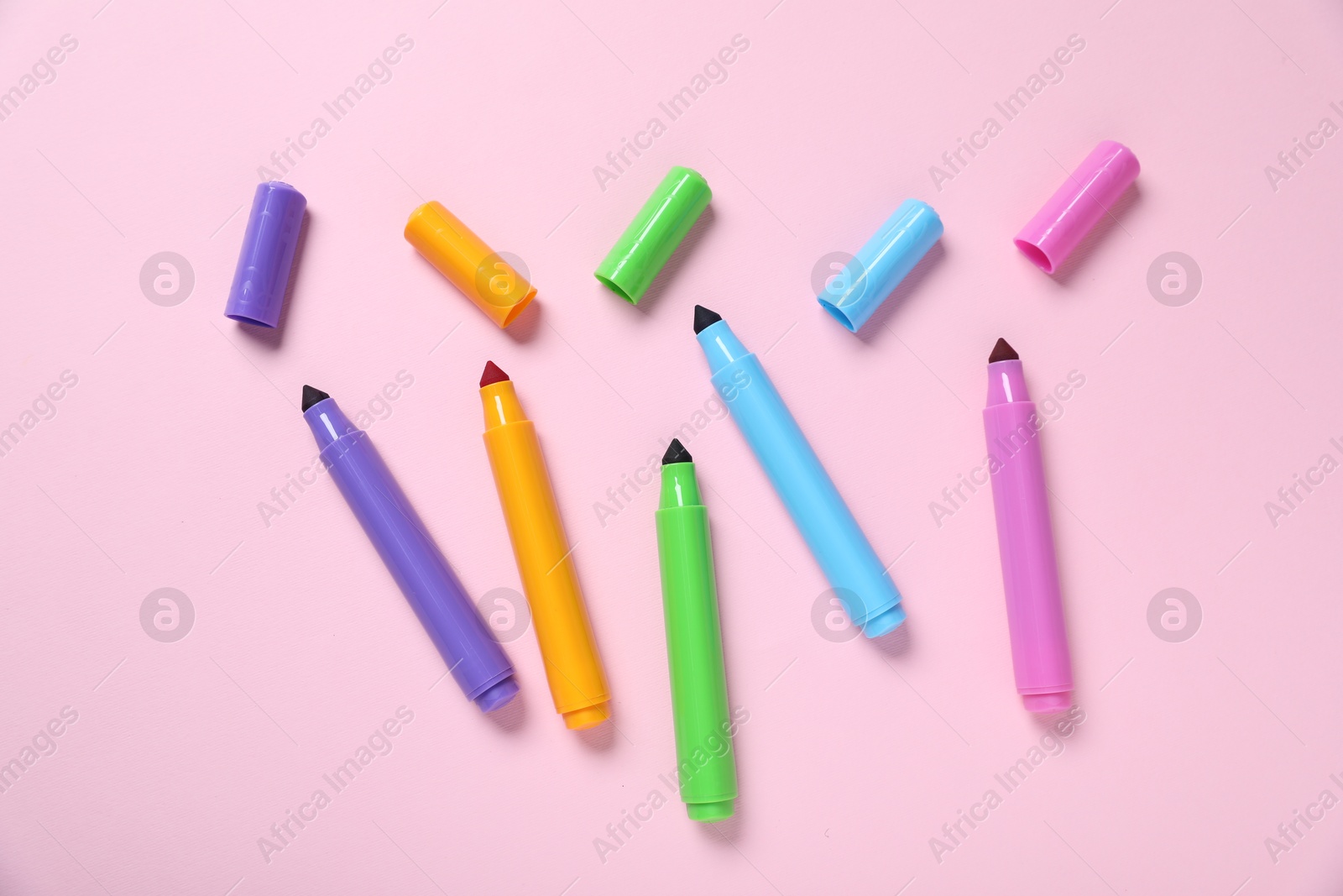 Photo of Many colorful markers on pink background, flat lay