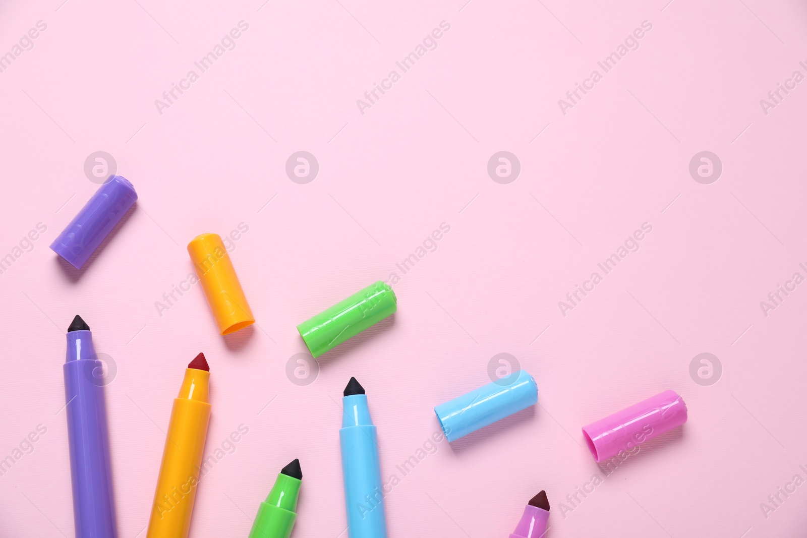Photo of Many colorful markers on pink background, flat lay. Space for text