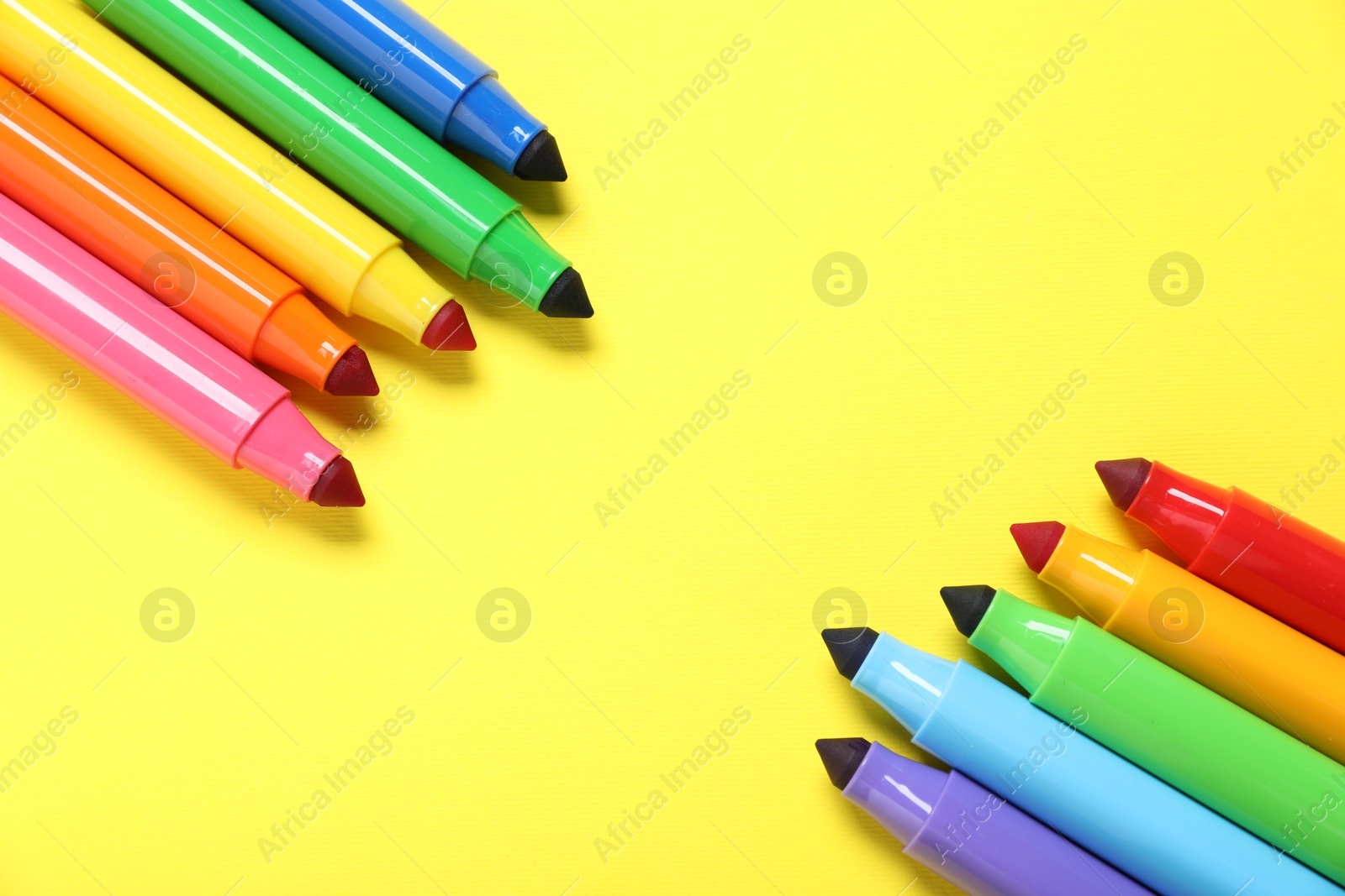 Photo of Many colorful markers on yellow background, flat lay. Space for text
