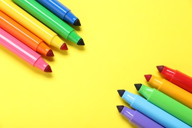 Photo of Many colorful markers on yellow background, flat lay. Space for text