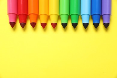 Photo of Many colorful markers on yellow background, flat lay. Space for text