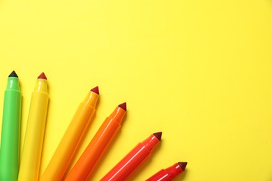 Photo of Many colorful markers on yellow background, flat lay. Space for text