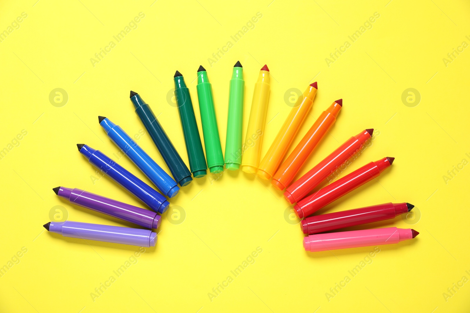 Photo of Many colorful markers on yellow background, flat lay