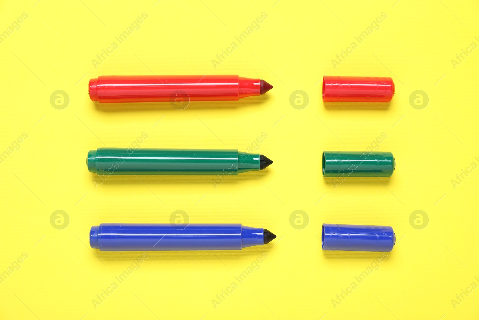 Photo of Many colorful markers on yellow background, flat lay