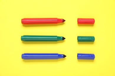 Photo of Many colorful markers on yellow background, flat lay