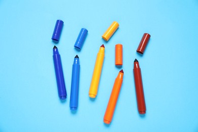 Photo of Many colorful markers on light blue background, flat lay