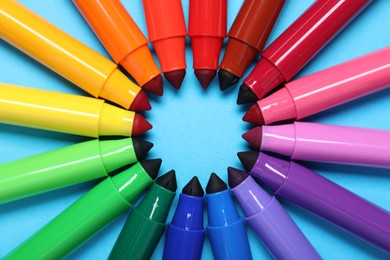 Photo of Many colorful markers on light blue background, flat lay