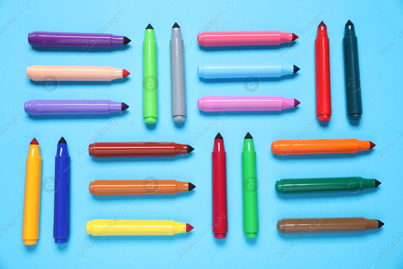 Photo of Many colorful markers on light blue background, flat lay
