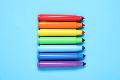 Photo of Many colorful markers on light blue background, flat lay