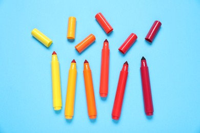 Photo of Many colorful markers on light blue background, flat lay