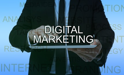 Image of Digital marketing. Businessman holding tablet computer and words on light blue background, closeup