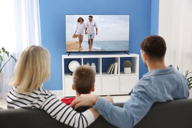 Image of Family watching movie on TV set at home