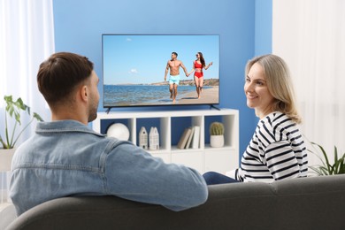 Image of Couple watching movie on TV set at home